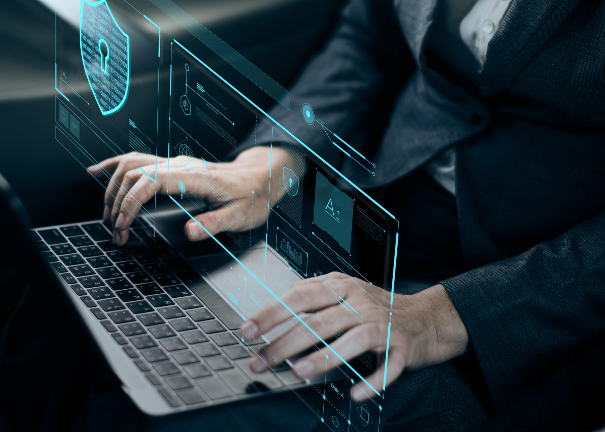 Man working on laptop with protection icons floating around