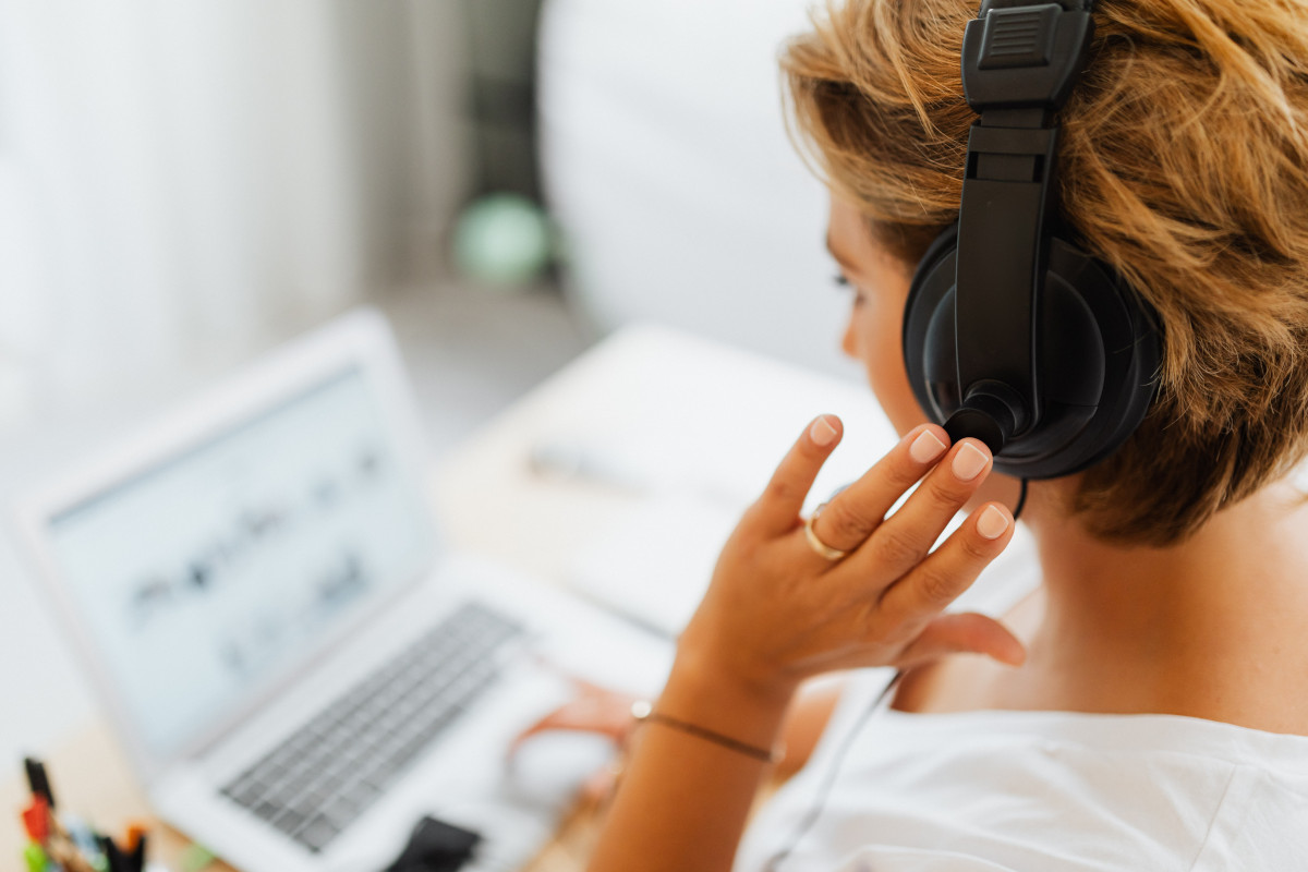 Woman working on laptop and wearing headphones